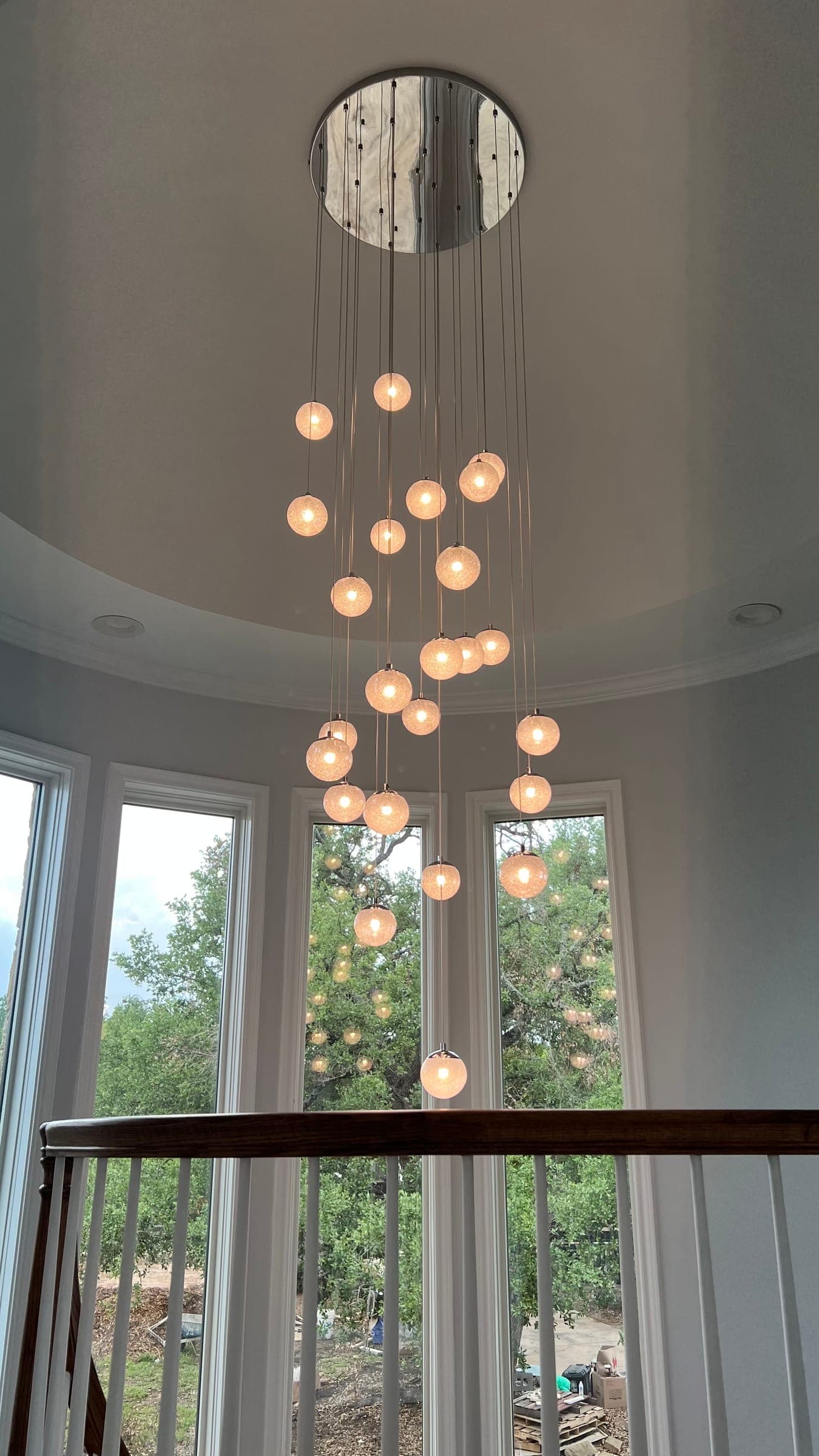 Cluster of warm glass pendants hung at varying heights in a turret window