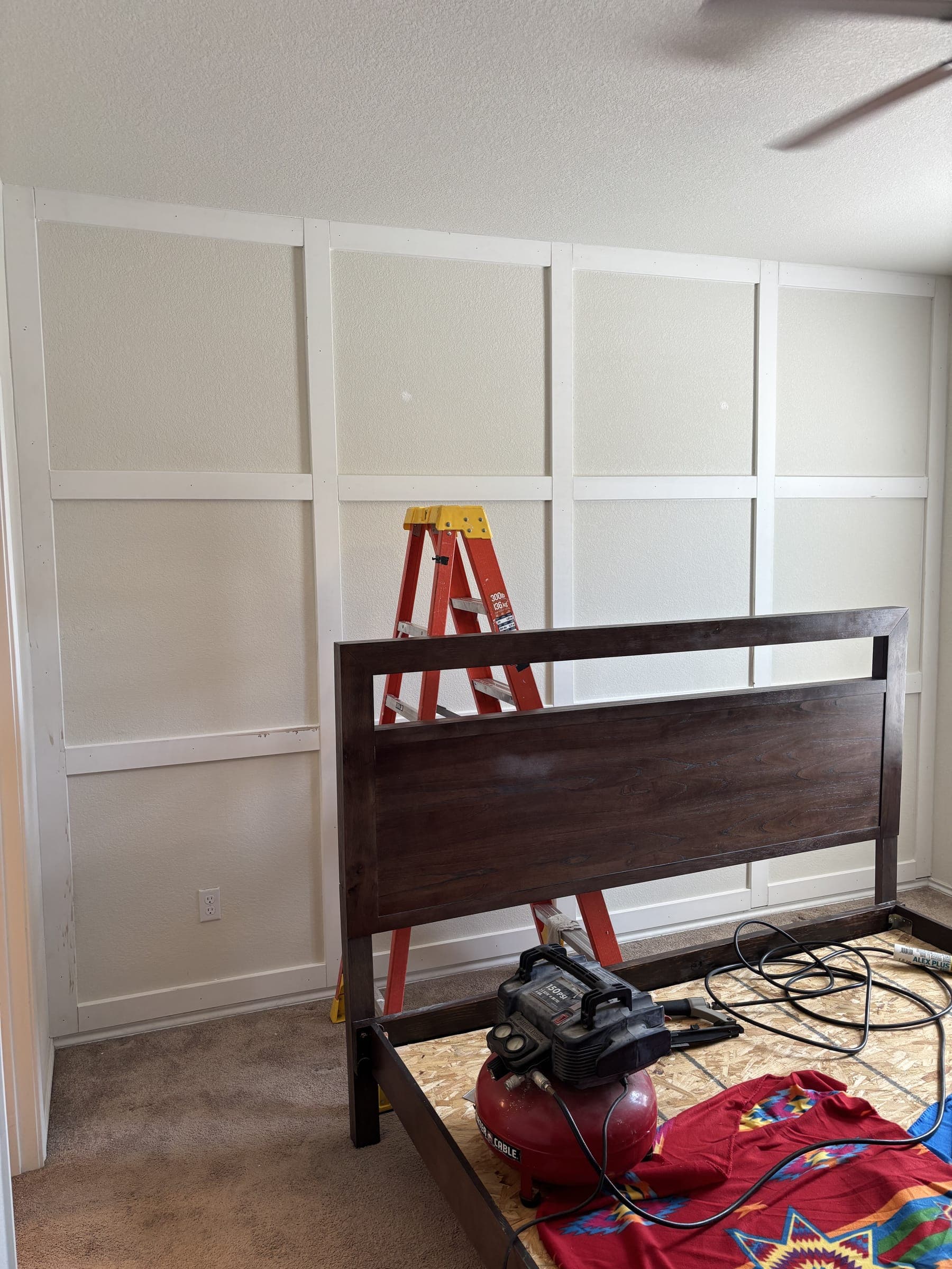Bedroom wall part-built, batten grid up and a ladder still in the room