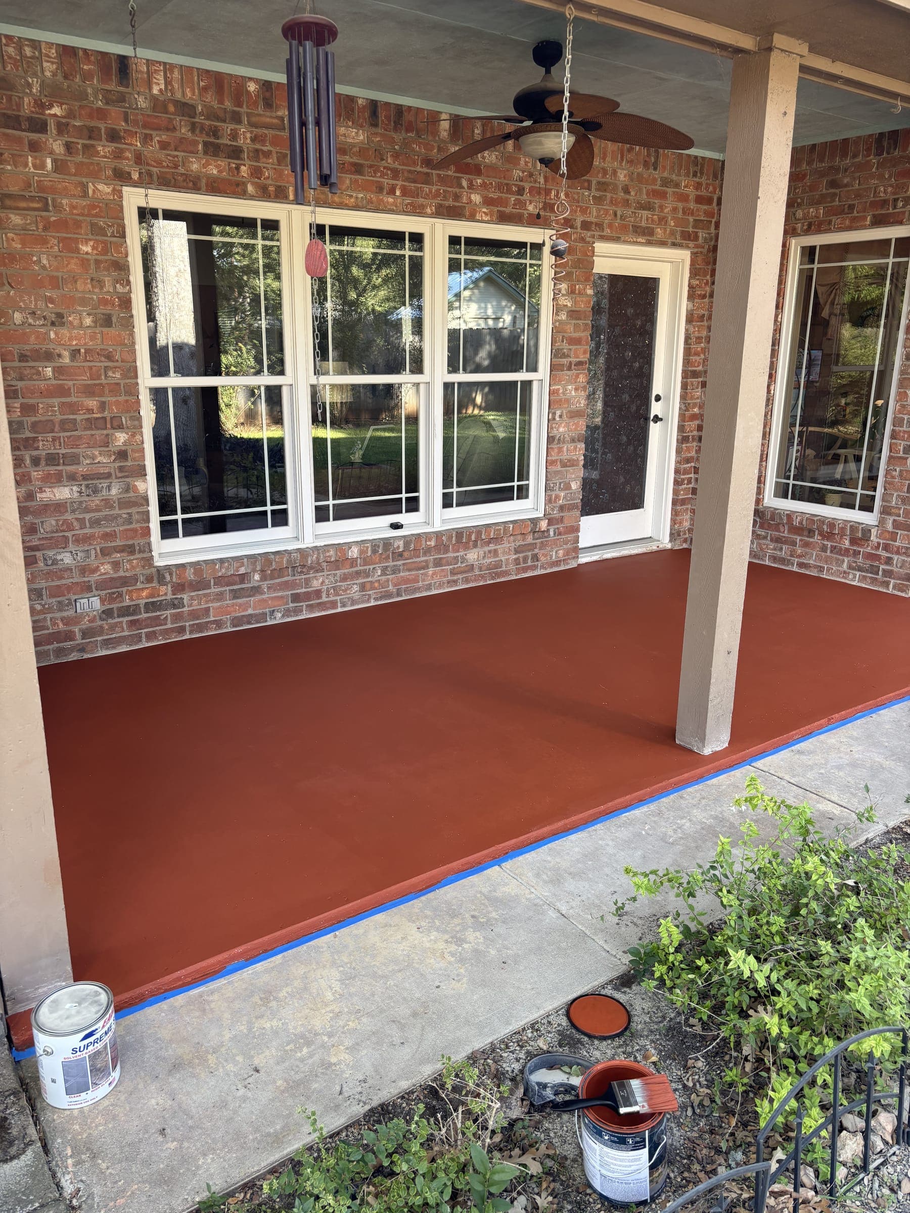 Covered patio finished in a deep terracotta coating against brick